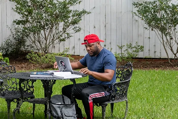 VSU online college student working on his laptop outdoors.